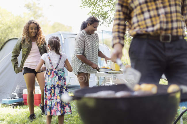 Family barbecuing, preparing lunch at campsite — Stock Photo
