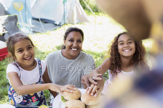 Vater serviert Grillhamburger an eifrige Familie auf Campingplatz — Stockfoto