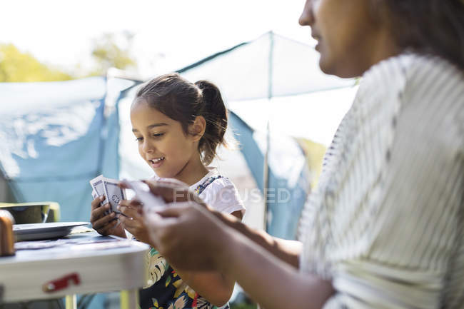 Mother and daughter playing card game at campsite — Stock Photo