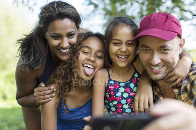 Familia juguetona tomando selfie con teléfono de la cámara - foto de stock