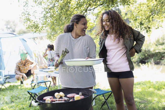 Mother and daughter barbecuing at campsite — Stock Photo