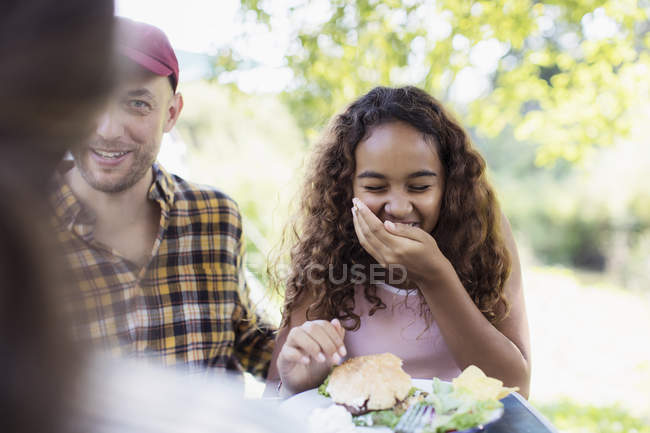 Chica riendo comiendo hamburguesa barbacoa - foto de stock