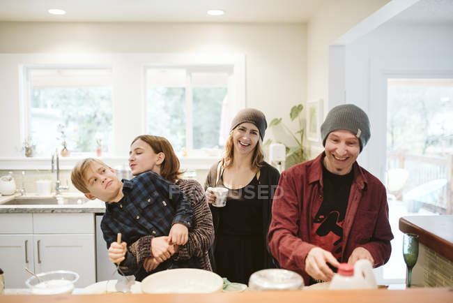 Retrato feliz, familia juguetona hornear en la cocina - foto de stock