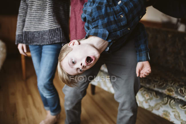 Verspielter Junge hängt kopfüber — Stockfoto