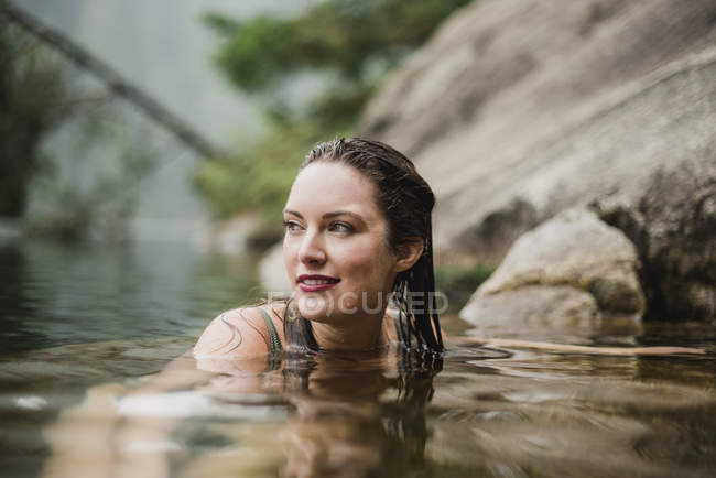 Lächelnde schöne Frau schwimmt im See — Stockfoto