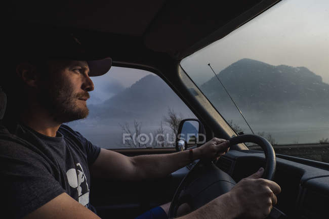 Чоловік керує вантажівкою поблизу гір — стокове фото