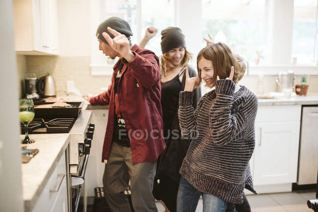 Despreocupada familia bailando y cocinando en la cocina - foto de stock