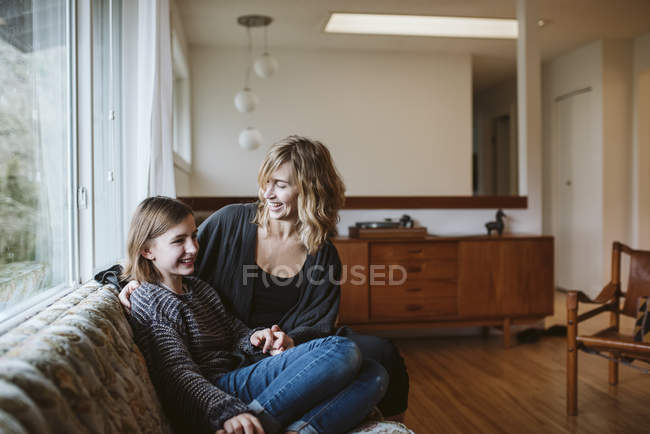 Mãe e filha de ligação no sofá da sala de estar — Fotografia de Stock