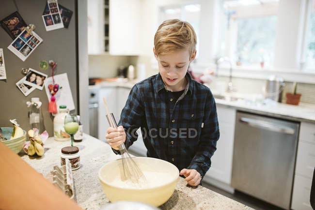 Між хлопчиком випічка на кухні — стокове фото