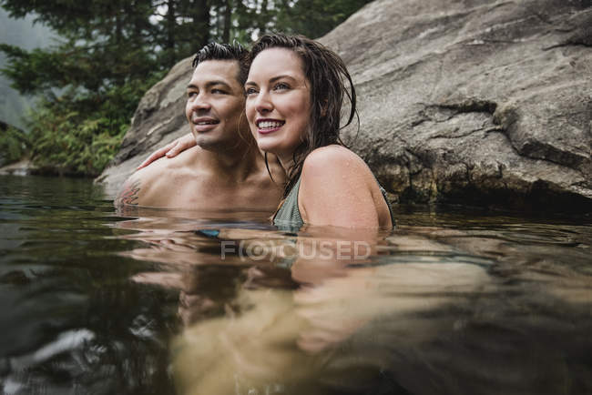 Liebevolles junges Paar schwimmt im See — Stockfoto