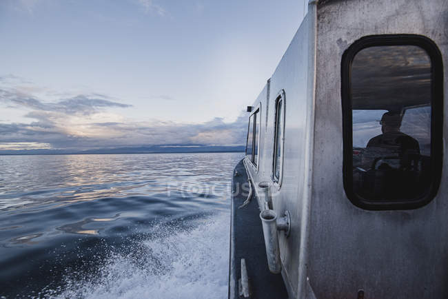 Капітан водіння човни на спокійній річці, Кемпбелл-Рівер, Британська Колумбія, Канада — стокове фото