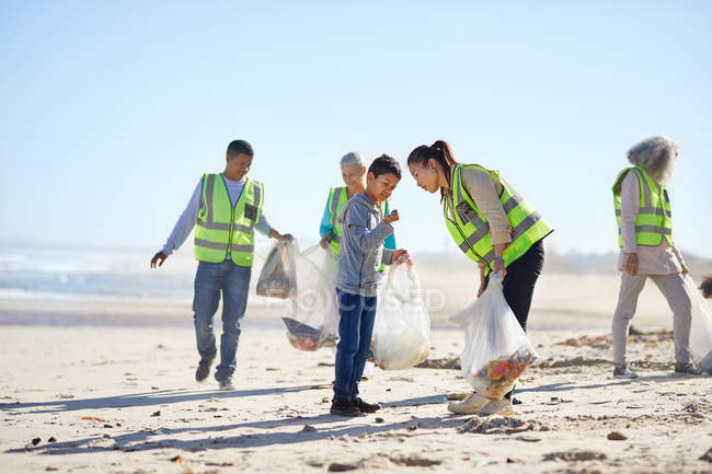 Volunteers cleaning up litter on sunny, sandy beach — Full Length ...