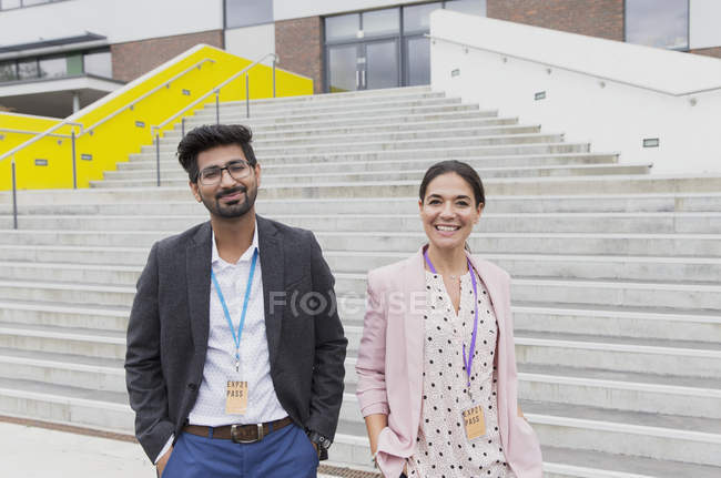 Portrait of confident teachers standing outside school building steps — Stock Photo