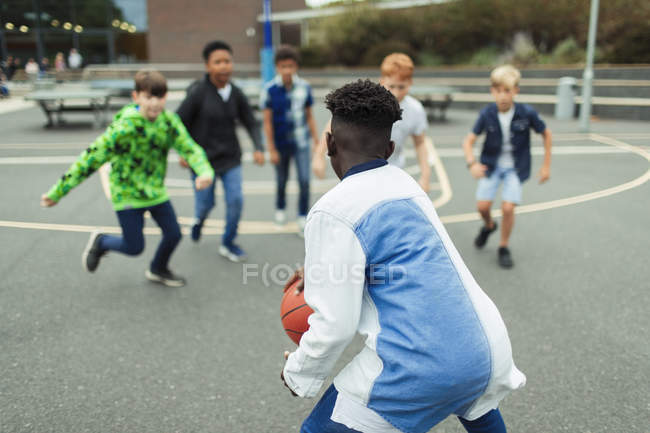 Мальчики играют в баскетбол на школьном дворе — стоковое фото