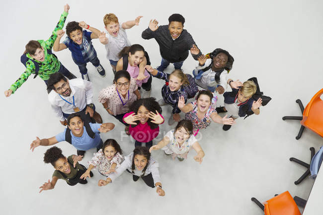 Portrait from above of enthusiastic junior high students and teachers cheering — Stock Photo