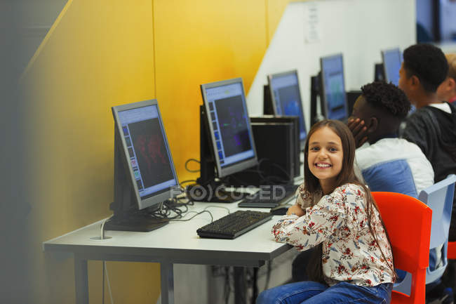 Портрет усміхненого, впевненого молодшого школяра, який використовує комп'ютер у комп'ютерній лабораторії — стокове фото