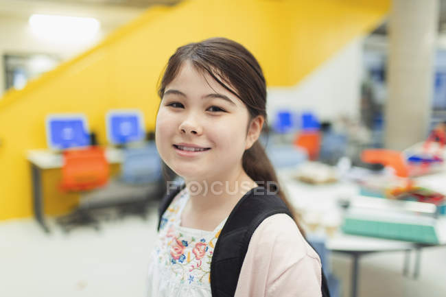 Portrait confiant junior lycéenne étudiante en bibliothèque — Photo de stock