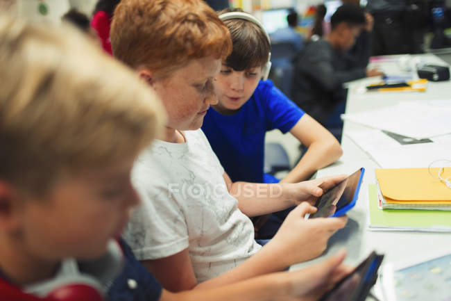 Meninos do ensino médio usando tablet digital em sala de aula — Fotografia de Stock
