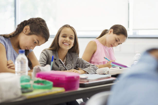Portrait of smiling, confident junior high school students studying in classroom — Stock Photo
