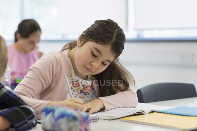 Konzentrierte Realschülerin macht Hausaufgaben im Klassenzimmer — Stockfoto
