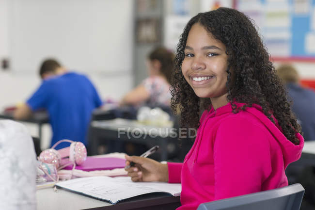 Портрет уверенного школьника, делающего домашнее задание в классе — стоковое фото