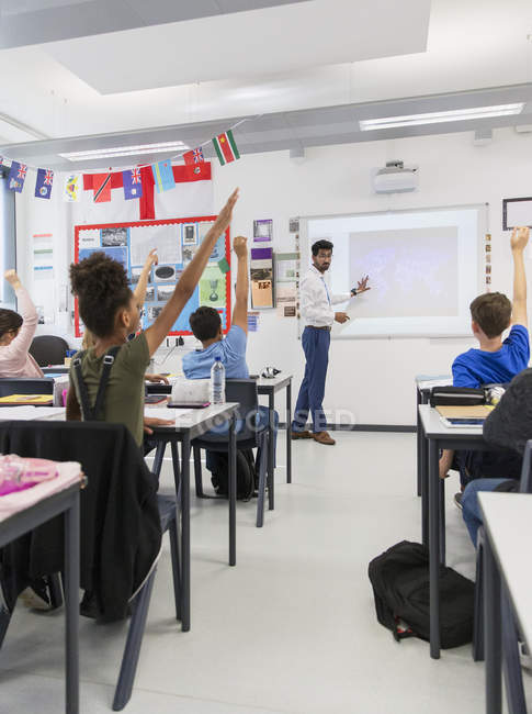 Male teacher leading lesson at projection screen in classroom — Stock Photo