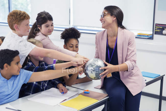 Eifrige Schüler berühren Globus in den Händen von Erdkundelehrern — Stockfoto
