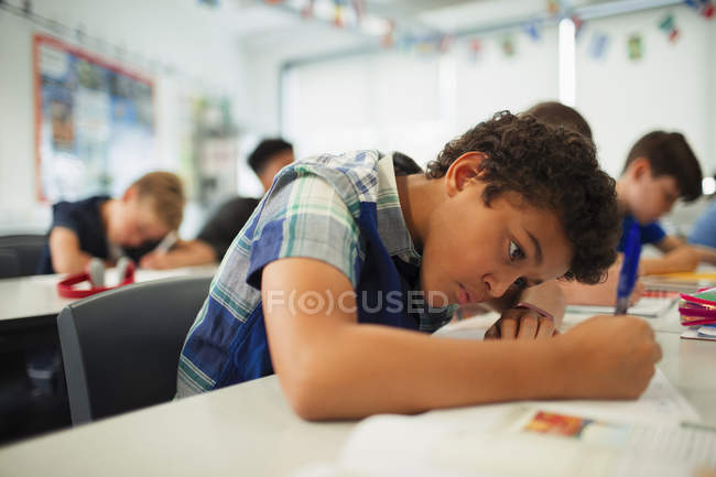 Орієнтовані молодші школярі роблять домашнє завдання в класі — стокове фото