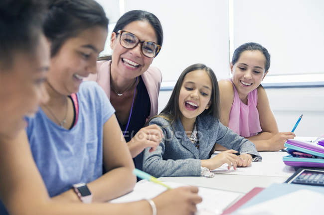 Enthusiastic female teacher and junior high school students in classroom — Stock Photo