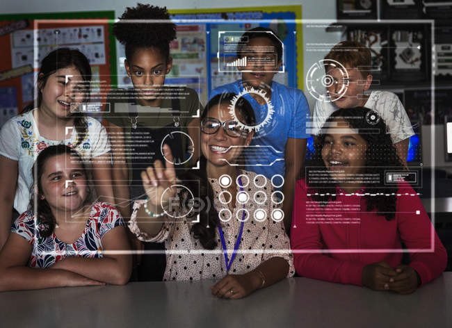 Profesor y estudiantes de secundaria utilizando la pantalla táctil futurista en el aula - foto de stock