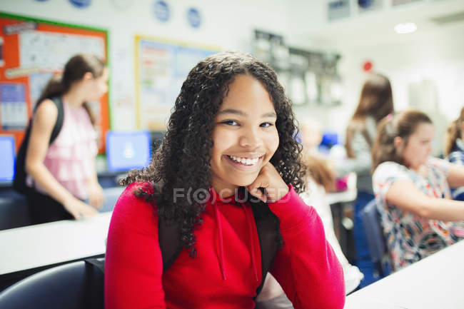 Retrato de chica sonriente, confiada en la escuela secundaria en el aula - foto de stock