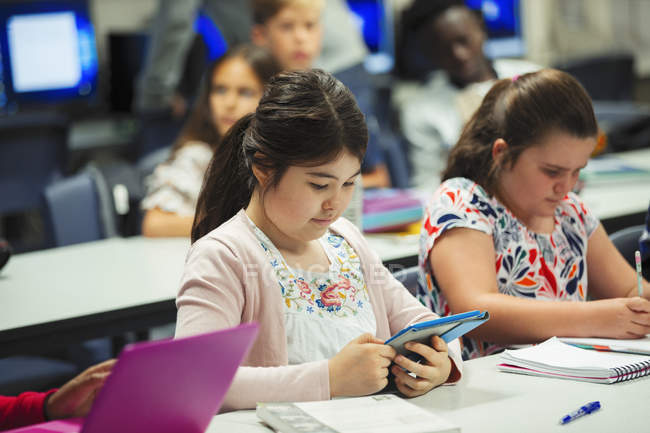 Studente della scuola media focalizzato utilizzando tablet digitale in classe — Foto stock