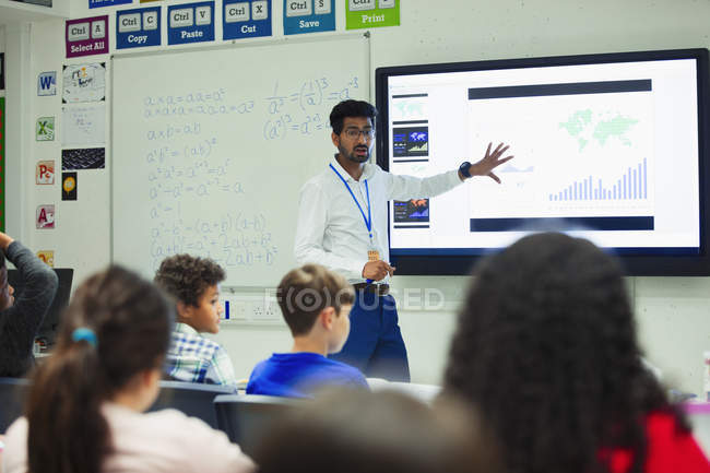 Professor do sexo masculino na tela sensível ao toque lição de liderança em sala de aula — Fotografia de Stock
