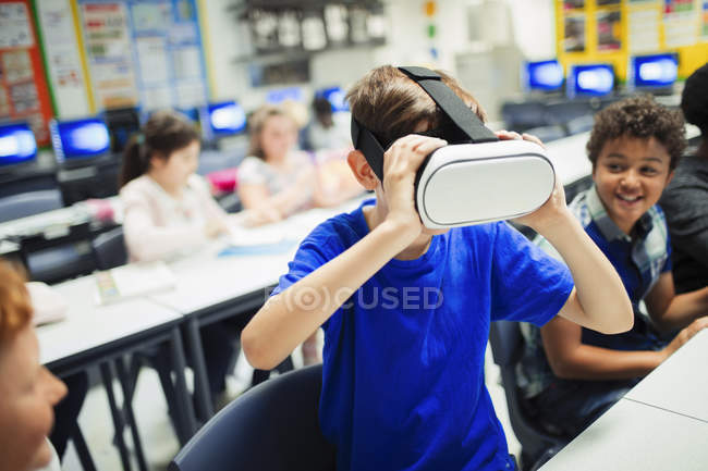 Молодший школяр використовує окуляри симулятора віртуальної реальності в класі — стокове фото