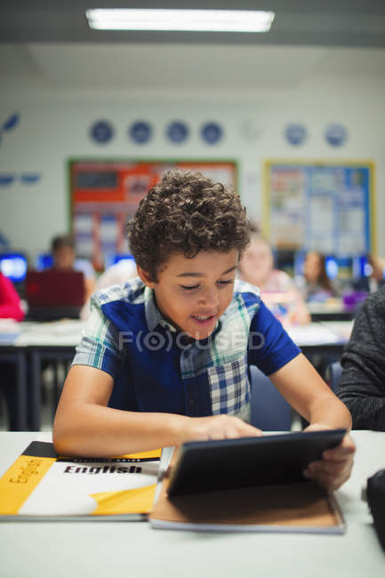 Молодший школяр використовує цифровий планшет у класі — стокове фото