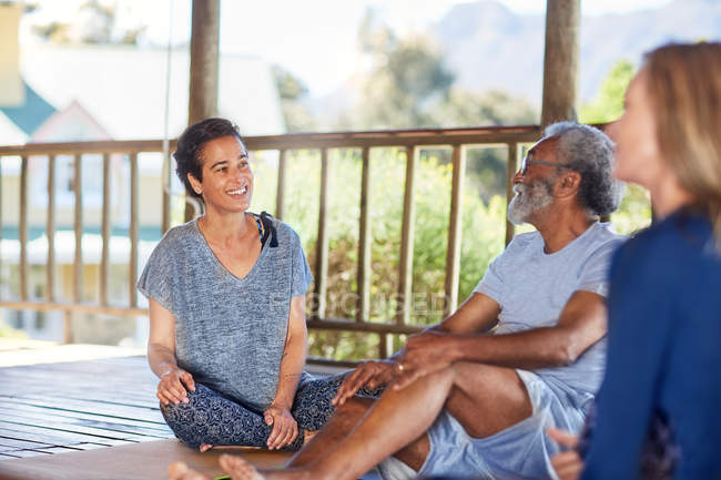 Усміхнений чоловік і жінка розмовляють в хатинці під час відступу йоги — стокове фото