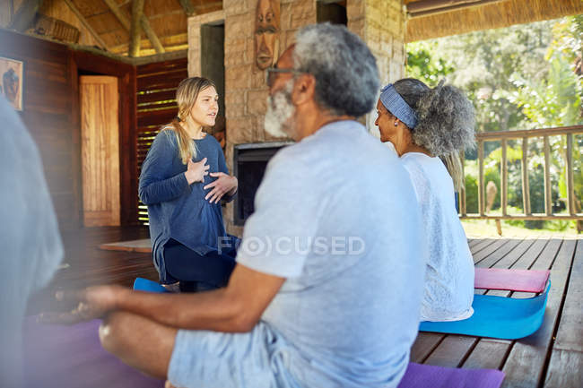 Instructor de yoga que dirige la meditación en la cabaña durante el retiro de yoga - foto de stock