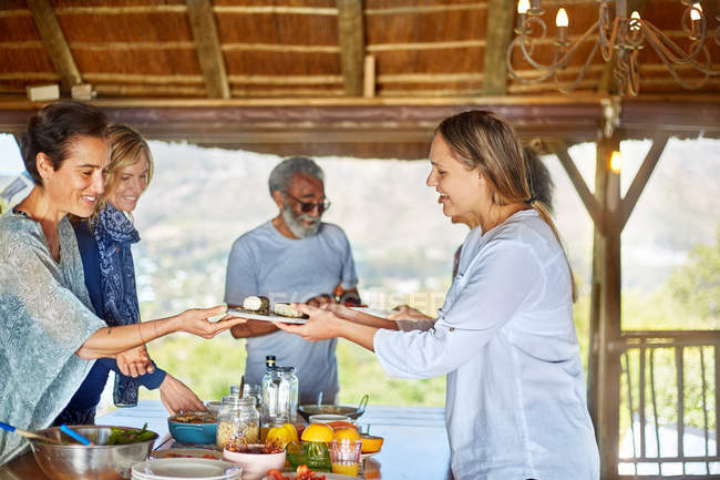 Group eating healthy breakfast in hut during yoga retreat — Stock Photo
