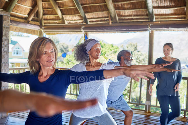Yoga-Kurs praktizierender Krieger 2 posiert in Hütte während Yoga-Retreat — Stockfoto
