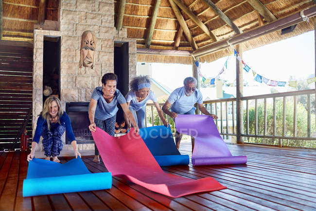 Les gens déroulent des tapis de yoga dans la cabane pendant la retraite de yoga — Photo de stock