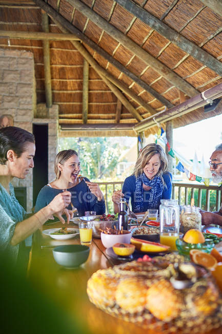 Amigos disfrutando de una comida saludable en la cabaña durante el retiro de yoga - foto de stock