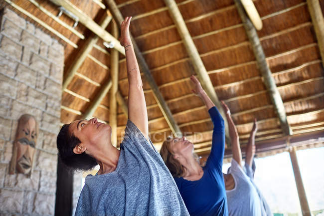 Mulheres praticando ioga durante retiro na cabana — Fotografia de Stock
