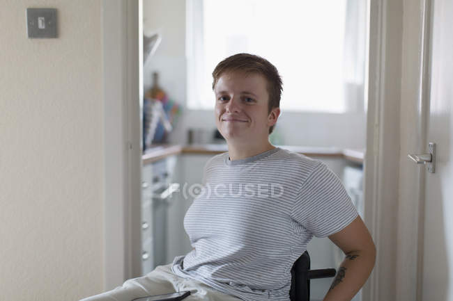 Retrato confiante jovem mulher em cadeira de rodas em casa — Fotografia de Stock