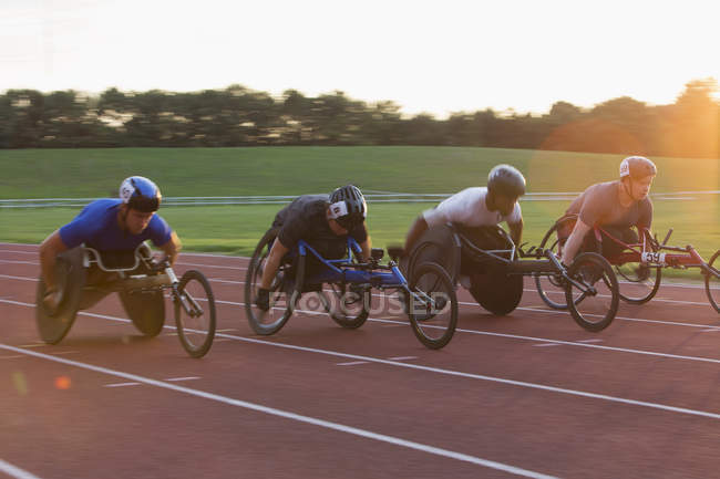 Паралитические спортсмены, мчащиеся по спортивной трассе в гонке на инвалидных колясках — стоковое фото
