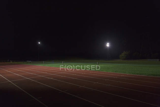 Piste de sport sombre la nuit — Photo de stock