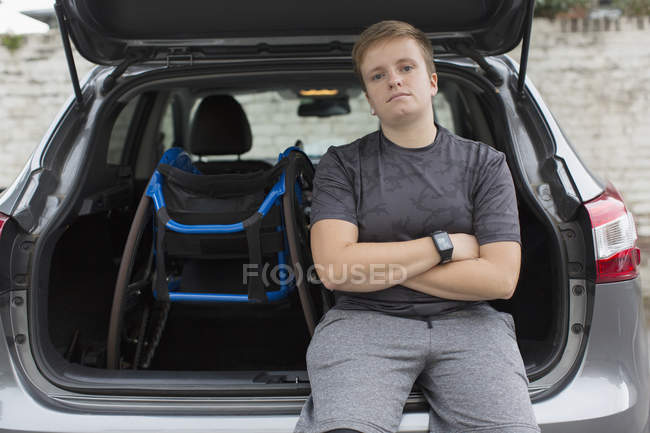 Portrait confident young woman with wheelchair at back of car — Stock Photo