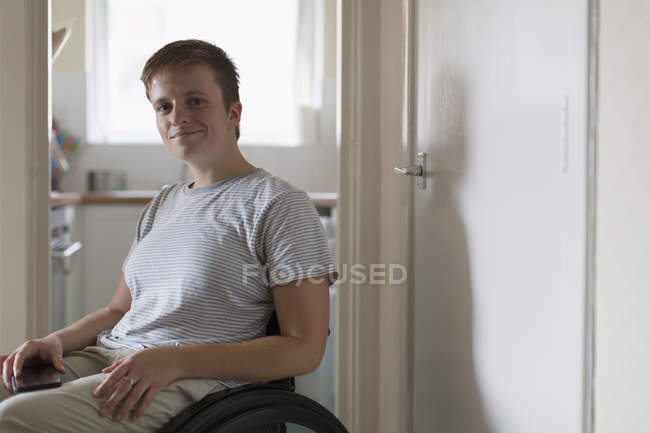 Retrato confiante jovem mulher em cadeira de rodas em casa — Fotografia de Stock