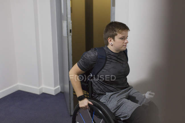 Молода жінка в інвалідному візку виходить з ліфта — стокове фото