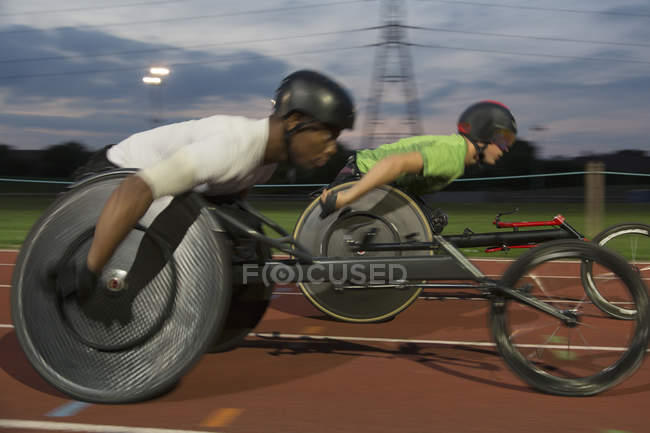 Paraplegic athletes speeding along sports track in wheelchair race — Stock Photo
