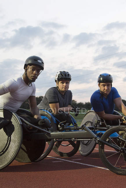Портрет впевнений, визначені паралельні спортсмени тренування для гонки на інвалідних візках на спортивній доріжці — стокове фото